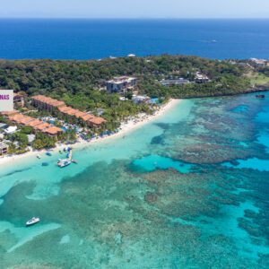 A view of the ocean from above shows boats and hotels.