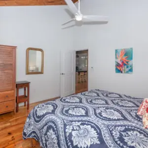 A bedroom with a bed, dresser and mirror.