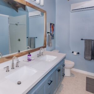 A bathroom with two sinks and a mirror.