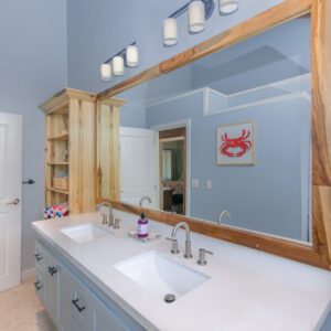 A bathroom with two sinks and a large mirror.