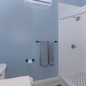 A bathroom with blue walls and white tile floors.