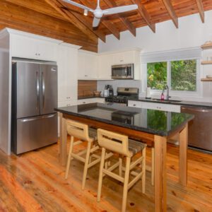 A kitchen with wooden floors and black counter tops.