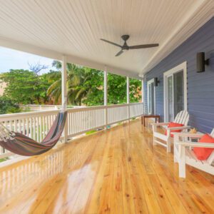 A porch with two chairs and a hammock.