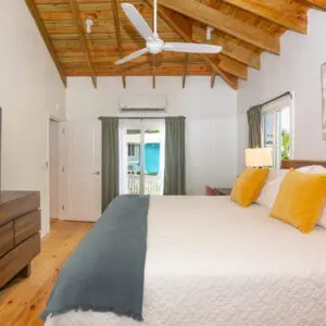 A bedroom with a bed, dresser and tv.