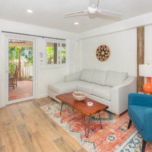 A living room with white furniture and wooden floors.