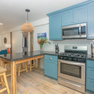 A kitchen with blue cabinets and stainless steel appliances.