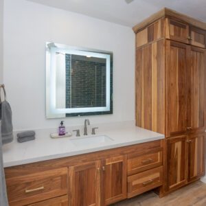 A bathroom with wooden cabinets and white walls.